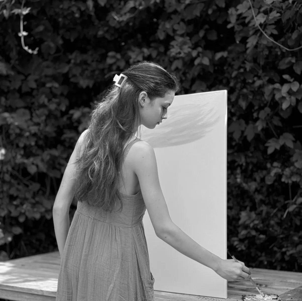 Isabella painting at her easel in the garden
